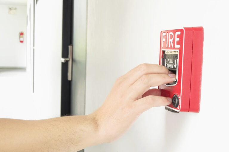 Main déclenchant une alarme incendie